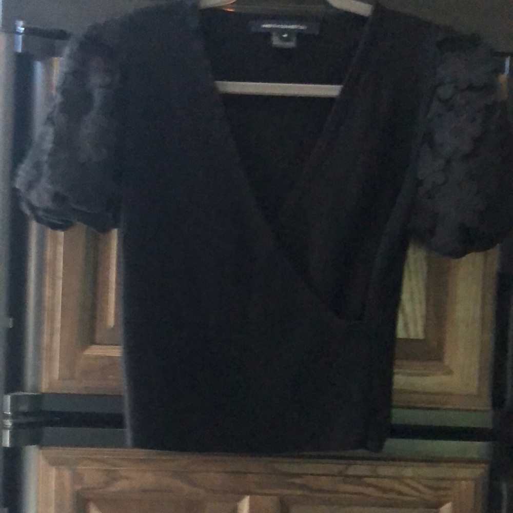 Black top with flowers sleeves. No stains. Like new. No tags.